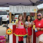 Salvation Army Disaster Worker poses with young girl at lemonade stand